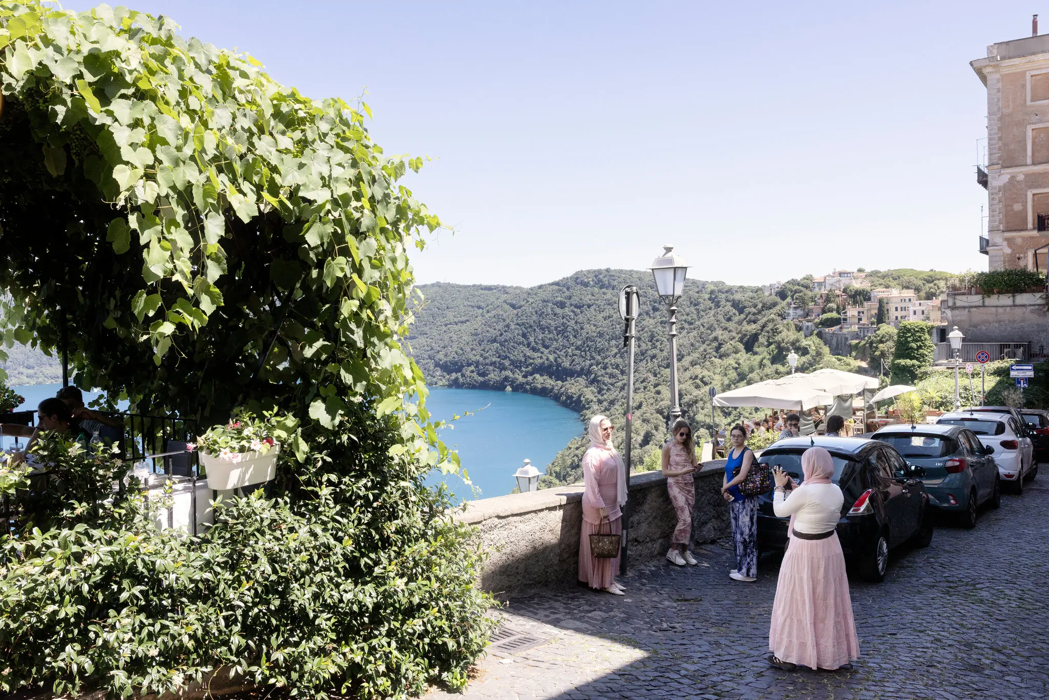 Туристи позують для фотографій у Кастель-Гандольфо, Італія, у червні. Заплановане повернення Папи Римського «дало місту іскру», сказав власник бару на головній площі міста.
